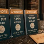 Panneaux agence immobilière À vendre devant une vitrine