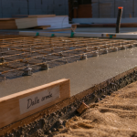 Dalle en béton armé : treillis d’acier et béton frais sur chantier