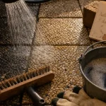 Nettoyer des dalles gravillonnées noircies : brosse et eau chaude entre les gravillons